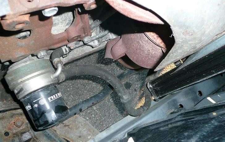 Daihatsu Charade Udstyr og Varianter - Som på billedet her kan det ses at 4WD modellerne blev leveret med det man kalder for en oliekølings snegel.

Den virker på den måde at i bunden af motorkøleren går der en studs ud hvor køler vandet er koldest, herfra går der så en slange over til sneglen der sidder mellem olie filteret og olie blokken.
Inde i sneglen løber vandet så i sin egen kanal tæt op af olie kanalen og på den måde køler den så olien ned.
Men da vandet skal videre går der så en studs ud igen hvor vandet ledes videre op og ind i topstykket hvor vandet i forvejen er varmt og på den måde skabes også et naturligt flow ved hjælp af kulde og varme flowet.

På en Charade med automatgear som de også findes med, der er også olie køling på, men her er det ikke motor olien som køles ned men derimod gearkasse olien.
Så køleren til en sådan bil har 2 studser hvor vandet så går over og køler gear olien og løber tilbage i toppen af køleren. billede 12