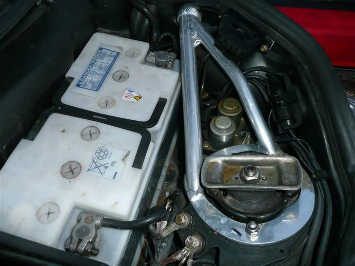 BRABUS W124 Ground Zero installation Stealth - BIlen blev bestilt med et større batteri fra fabrikken af.
Der sidder derfor et 100Ah batteri i bilen fra standart med 850A Start strøm hvis ikke mere :o)

Som man også kan se så har bilen fået en Krængnings stabilisator monteret og denne kommer desværre uhyggeligt tæt på batteriets plus pol som sidder længst væk i billede.
Dette var lidt af en udfordring for mig, men jeg fik monteret et stykke beskyttelses plastik rundt om aluminiums rørret der går lige forbi plus polen, det er alt for tidlig at skulle til at svejse på denne her bil nemlig :o) og så er jeg da lidt sikret mod en evt. kortslutning. billede 22