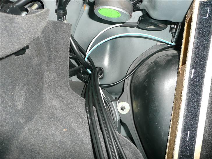 BRABUS W124 Ground Zero installation Stealth - Her ses omme fra bagerummet i venstre side mine 3 Signal kabler (front, bag og Sub)
Det er kablerne som kommer nederst i billedet.
Til højre ses siden af det "hemmelige rum" hvor der er et hul for oven til gennemføring af kablerne.
Som det kan ses er kabelførings hullerne ikke for store og når så 3 trippel skærmede signal kabler kommer og vil lege med i hullet :o) ja så er pladsen brugt op og derfor måtte jeg trække højttaler kablerne i den anden side sammen med Strømkablerne. billede 26