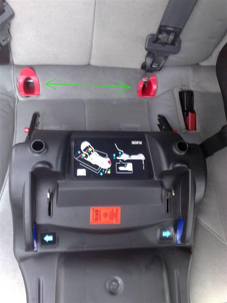 Isofix i Renault Laguna - I denne Renault Laguna var jeg nødt til at skære lidt i syningerne i sædet, for at få adgang til Isofix-beslagene under sædet. Det er helt normal procedure for denne bil og er desuden beskrevet i Instruktionsbogen.. De grønne pile viser, hvor og hvordan de to røde "styr" skal sidde, når tilgangen er opnået.. billede 1