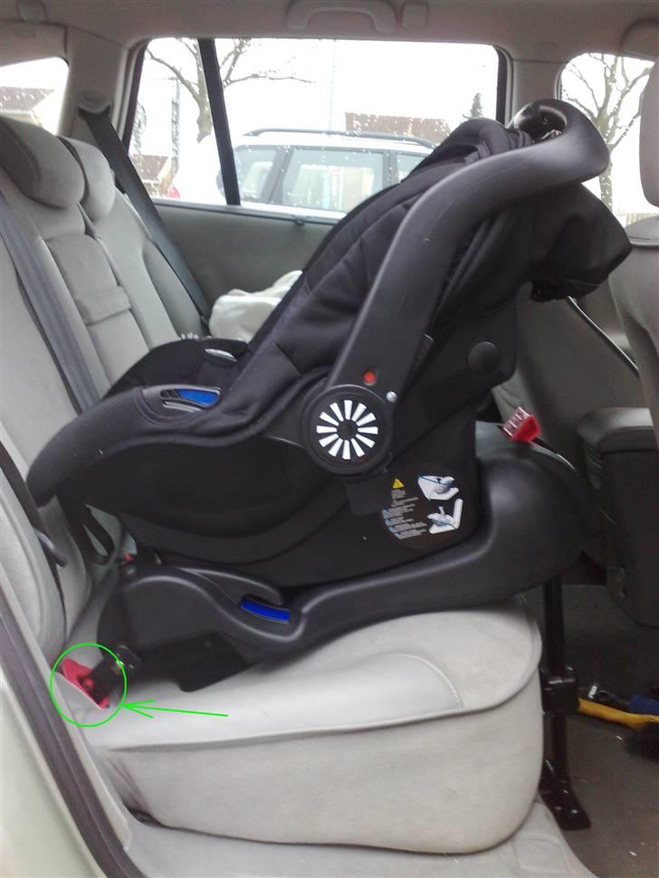 Isofix i Renault Laguna - Barnestolen er monteret på Basen. De grønne pile viser hvor Basens Isofix-stænger går ned i styrene og fanger beslagene i bunden af bilen.. Bemærk også det justerbare "støtteben", der støtter Base og stol.. billede 4