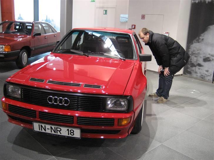 Audi S / RS og R billeder og forklaringer - RS - Modelfamilien
RS står for Renn Sport

Sport Quattro B2 1983 - 1985

Audi Sport Quattro kan man vel godt kalde den allerførste ”RS model”. 

Efter Audi startede med deres Quattro model i rally i 1981 og fik en 3. plads, arbejdede teamet videre med Audi Quattro i 1982, og fik en 2 og 3 plads, incl. 1. Plads i konstruktørmesterskabet. I 1983 fik de så deres første VM titel. Men konkurrencen var i tidens løb gået hen og blevet mere og mere hård. Med rene racing-maskiner, såsom Peugeot 205 Turbo 16 med midt monteret motor, blev grundlag for at Audi skulle til at forbedre sig. Der blev derfor designet en helt ”ny” Audi i 1983 - Sport quattro’en, også kaldet "Den korte". Selvom Sport quattro og quattro ser temmelig ens, har de ikke mere tilfældes end deres navne. Audi Sport Quattro blev på det Internationale Motor Show i 1983, vist frem til offentligheden for første gang. I december 1984 begyndte produktionen så for alvor. Audi fik hermed deres anden første plads i træk, og en første plads i konstruktørmesterskabet. I 1985 blev det til en anden plads. På grund af den tids FIA regler for gruppe B biler skulle der produceres mindst 200 eksemplarer for at kunne bruge den i rally der blev dog produceret 224 køretøjer i alt. Motoren i Audi Sport quattro producerede 225 kW (306 hk) og 350 Nm i drejningsmoment. De fem-cylindrede fire-ventil motor med turbolader for K27 KKK tilladt med et tryk op til 2,04 bar.
Disse fordelte sig således: 

4 stykker i individuelle forhånd samlede dele, som ikke var afsluttet (angiv Audi Motorsport) 
134 stykker i Tornadorot 
48 stykker i Alpine White 
21 stykker i Kopenhagenblau 
15 stykker i malachitgrønt 
2 stykker i sort 
Af køretøjer i farven Tornadorot kom 89 i frit salg. Seks biler var prototyper, 19 blev prøvekøretøjer og 20 biler blev brugt som udviklings biler af Audi Motorsport selv. Det skal bemærkes, at tre køretøjer er E2 versioner med 400 kW (544 hk) blev bygget og fik godkendelse til brug på offentlig vej, hvoraf den ene har været ejet Armin Schwarz.
Audi Sport quattro kunne i december 1984 købes til en pris af DM 195.000 og var på det tidspunkt dyreste tyske producerede køretøj. Til sammenligning kostede en Porsche 911 Turbo kun halvdelen af den pris, nemlig 100.000 DM fra den 1. Januar 1985, blev forhøjet til 203.850 DM. Selv i dag, ligger prisen for en Sport Quattro mellem 70.000 - 150.000 euro i god stand.

 billede 18