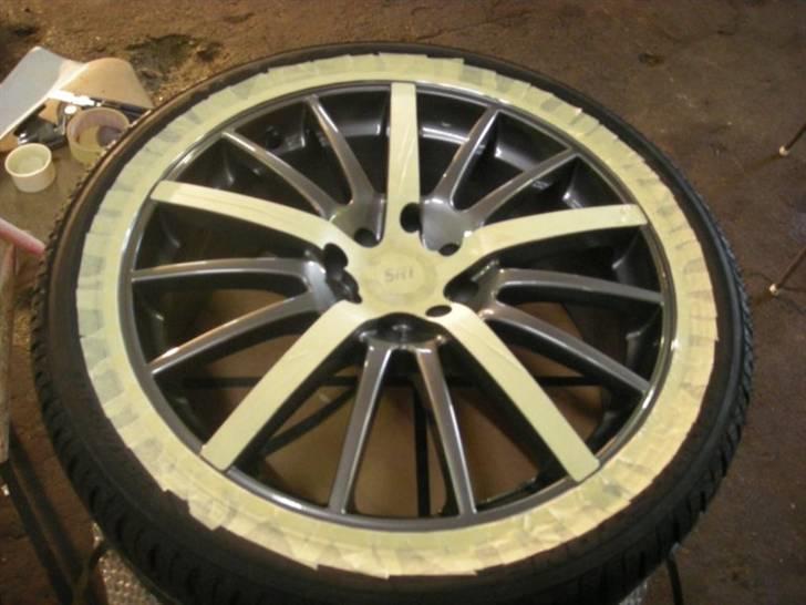 Maling af fælge - Så blev der afdækket med malertape. Det tog satme lang tid. Men hellere være grundig. Det er forarbejdet der afspejler resultatet i sidste ende. På de blanke eger som ikke skulle males kom jeg tape på som stak ud over og så tog jeg en hobby kniv og skar langs med og fik det overskydende tape væk. Det er med tungen lige i munden og skal være præcist. Til sidst fik de grå eger med fin sandpapir så det sorte maling kan hæfte ovenpå det. billede 3