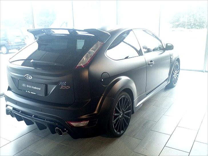 Focus RS 500 hos Brdr. Hosbond i Aalborg - RS500'eren bagfra.... Ser fedt ud med den 3M matsorte folie....

"Alle Focus RS500 bliver malet i standard Panther Black metallic inden de bliver transporteret til virksomheden 3M ved Frankfurt. Her bliver der påført en speciel folie for at give den matsorte effekt. Folien er ekstremt holdbar og designet til at modstå stenslag og småridser. Ved skader rykker en specialist fra 3M ud til ethvert autoriseret Ford-værksted i Europa, der udfører lakreparationer på bilen." billede 1
