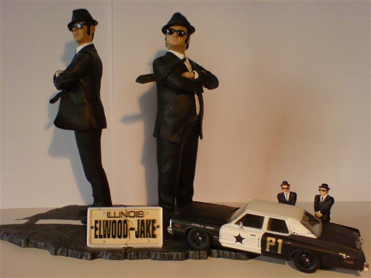 MODEL BILER i størrelse 1:43-1:24 og 1:18  - Corgi Blues Mobil, Speciel Universel Studio Edition...

Dodge Monaco. Str: 1.43

The Blues Brothers, Jake and Elwood. Små figure høre til Corgi modelbilen og så er der de store figurer, som er ved at være rigtig svære at få fat i. så de er ved at stige i pris i USA som brugte bla.

Bil. Str: 1:43

Jeg prøvede at lege lidt for at få et sjovt billede af bil og mine figurer, syntes elv det blev nogenlunde okay...
 billede 7