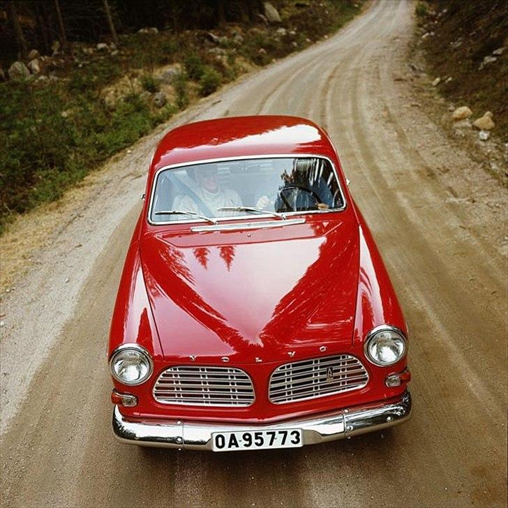 Volvo's 85 års jubilæum.  - VOLVO P130 AMAZON 2-D I PRODUKTION 1961-1970


I september 1961 præsenterede Volvo endnu en version baseret på 121/122S, nemlig en 2-dørs sedan. Denne version var en med længsel imødeset model, især i Sverige, som på det tidspunkt var et godt marked for 2-dørs biler. 

Teknisk var der ingen forskel på de to modeller. Dørene var naturligvis større på den nye 2-dørs model, så det var lettere at komme ind på bagsædet, og forsæderne kunne vippes frem af samme årsag. De bageste sideruder kunne åbnes i det bageste hjørne for bedre ventilation. 

Det var oprindeligt meningen, at motorprogrammet skulle være det samme som til 4-dørs modellen. Men eftersom 2-dørs versionen var noget lettere, blev den også opfattet som noget mere sporty og blev derfor brugt inden for motorsporten, både til rally og baneløb. 

For at understrege Amazonens sporty image blev den hurtige og rigt udstyrede 123GT lanceret i 1966, med den samme motor som til 1800S sportsvognen. 

I 1968 kom endnu en motorversion til – den såkaldte B20-motor, en 2,0-liters version. 

Produktionen af P130 fortsatte indtil den 2. juli 1970. Dette var den sidste version af denne bilfamilie, som blev produceret i 667.323 stk. i alt i årenes løb.  billede 20