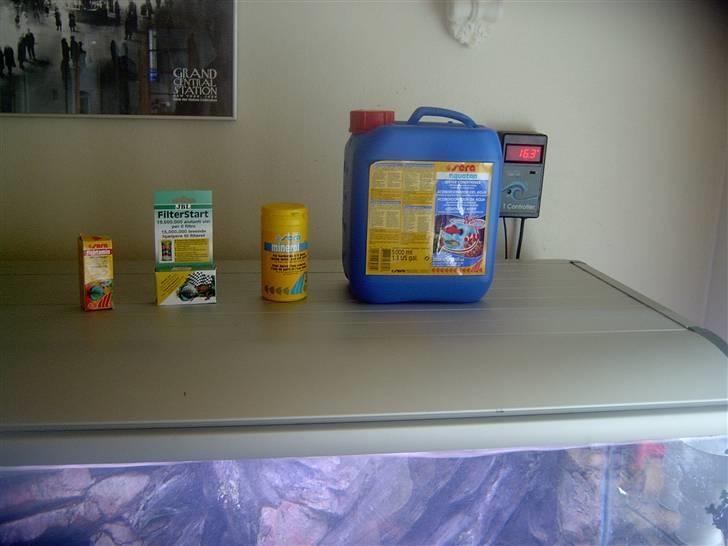 Opbygning af mit 720 L  - Så er alvariet fyldt op, og det nødvendige til akvariestart er gjort klart. Der er 580L vand. Og det er en godt ting at have styr på, så man ikke dossere efter 720L div. sten og filtermatriale skal ikke have behandling. Men man kan se temp. på controlleren i baggrunde som viser 16,3 så det er for tidligt at komme det i. Aquatanén er et middel der binder alle de tilsætningsstoffer der i vandet og skal tilsættes ca 1 døgn før filterstart tilsættes. På billedet er det vist en beholder filterstart, men det er desværre ikke nok. Der er oplyst at den svare til 3L filter. Så der skal indkøbes en del mere. Akvariesalten kan sagtens tilsættes men venter til vandet er oppe på den ønsket temp. Vitaminerne tilsættes først nå fiskene kommer i og skal tilsættes vandet eller i fodret. Men det nemmeste er at dryppe det i vandet og så slukke lyset. billede 16