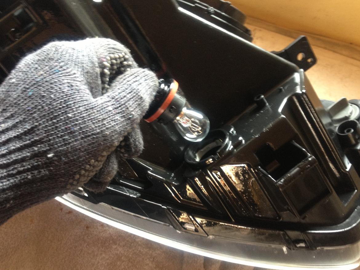 Kia Rio - LED lys montering  - Her er lygten vendt med bunden i vejret, her sidder køre lys pæren. Ud med den og i med den nye, nu skal det hele monteres. Samme procedure bare i baglæns rækkefølge.  billede 10