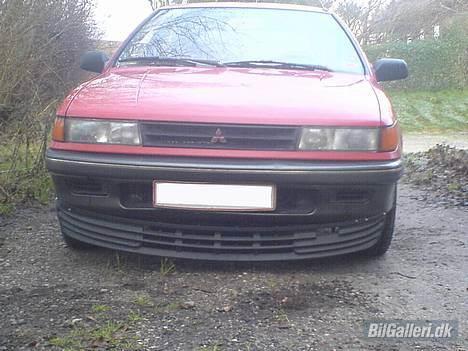 Mitsubishi Colt  - Hjemme i indkørslen. Forfra. Huha den skraber lige lidt på når jeg kører ind, så det går nok ikke at få den længere ned. billede 1