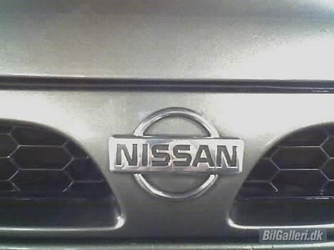 Nissan Sunny N14 (SOLGT) - det crome nissan logo i fronten af bilen billede 11