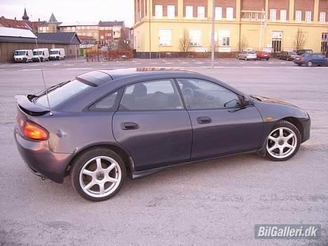 Mazda 323F BA - Det er ikke en bule på siden.. det er bare lyset.. men blev da os selv lidt nervøs da jeg så billedet og måtte da lige ud og se efter om der var noget jeg havde overset.. :D  billede 4