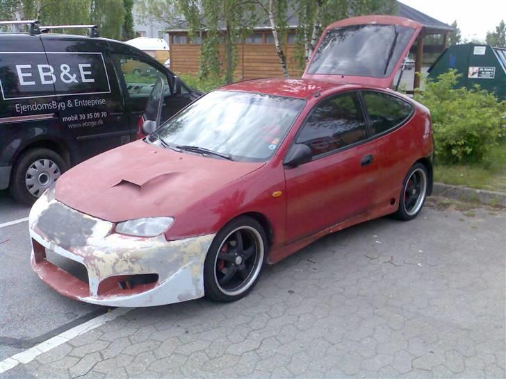 Mazda 323C Project Bil...SOLGT - Hvis man kigger efter på forkofangeren og det smil der er i siden så er det altså spartlet væk, og det ser meget bedre ud... billede 5