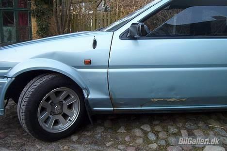 Toyota Corolla GT Coupé - Man kan se hvordan forskærmen har fået en ordentlig bule og døren også. Det kan dog redes. billede 6