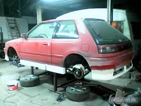 Mazda 323 1,8 GT TURBO - her er jeg så lige i krig med at spartle spoiler ind i kofangerne... det støver  lidt som det ses billede 5