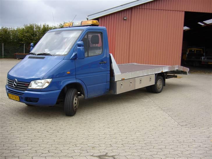 Mercedes Benz Sprinter Autotransporter - Så kom det nye lad på, her holder den foran Kolding Karoserifabrik, hvor jeg købte ladet.. Skabene der er monteret under ladet kostede 2.600,- ex moms, men med montering.. Der er monteret 3 stk, 2x 120 cm og 1x90 cm.  billede 1