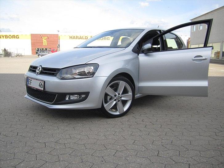 VW Polo 1,2 TSI Highline - Harald Nyborg skiltet i baggrunden kaster en glans af eksklusiv elegance over bilen. billede 2