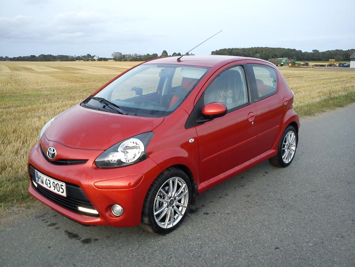 Toyota Aygo T2 Air Spice Edition - Synes de 16" Manaray passer rigtigt godt på den, men med passagerer bagi skal man sgu køre pænt hen over ujævnheder for ikke at skrabe mod skærmkassen :D billede 17