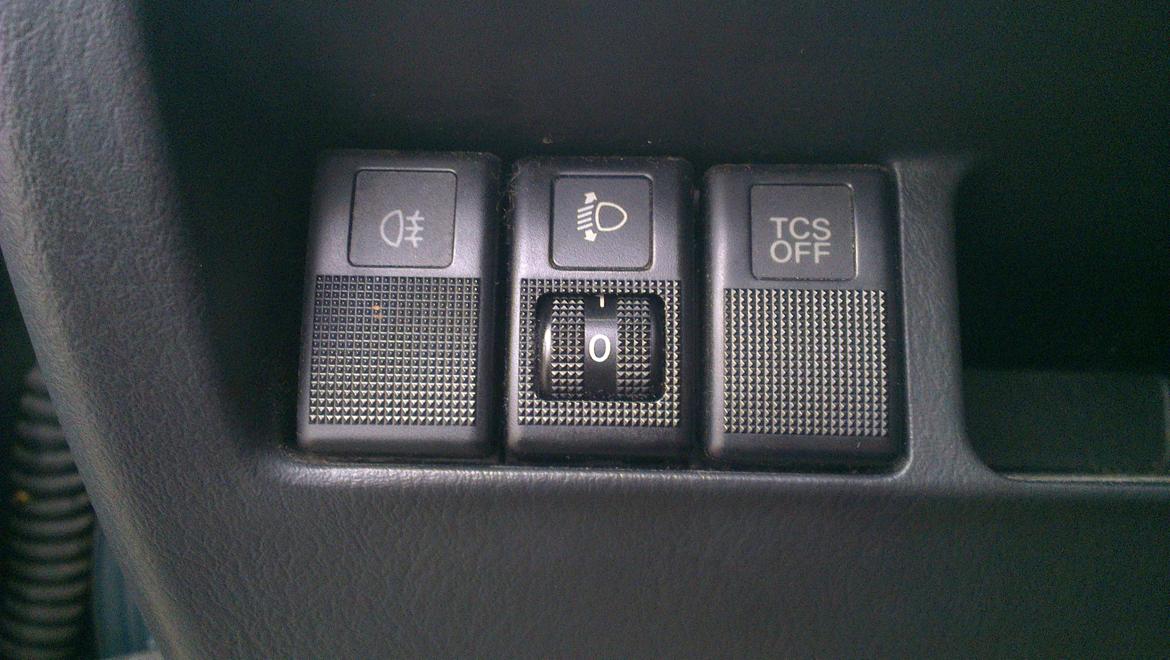 Mazda 626 GF - Knapper til tågelys bag.
Eljustering af forlygterne og til at slå TCS til og fra. billede 14
