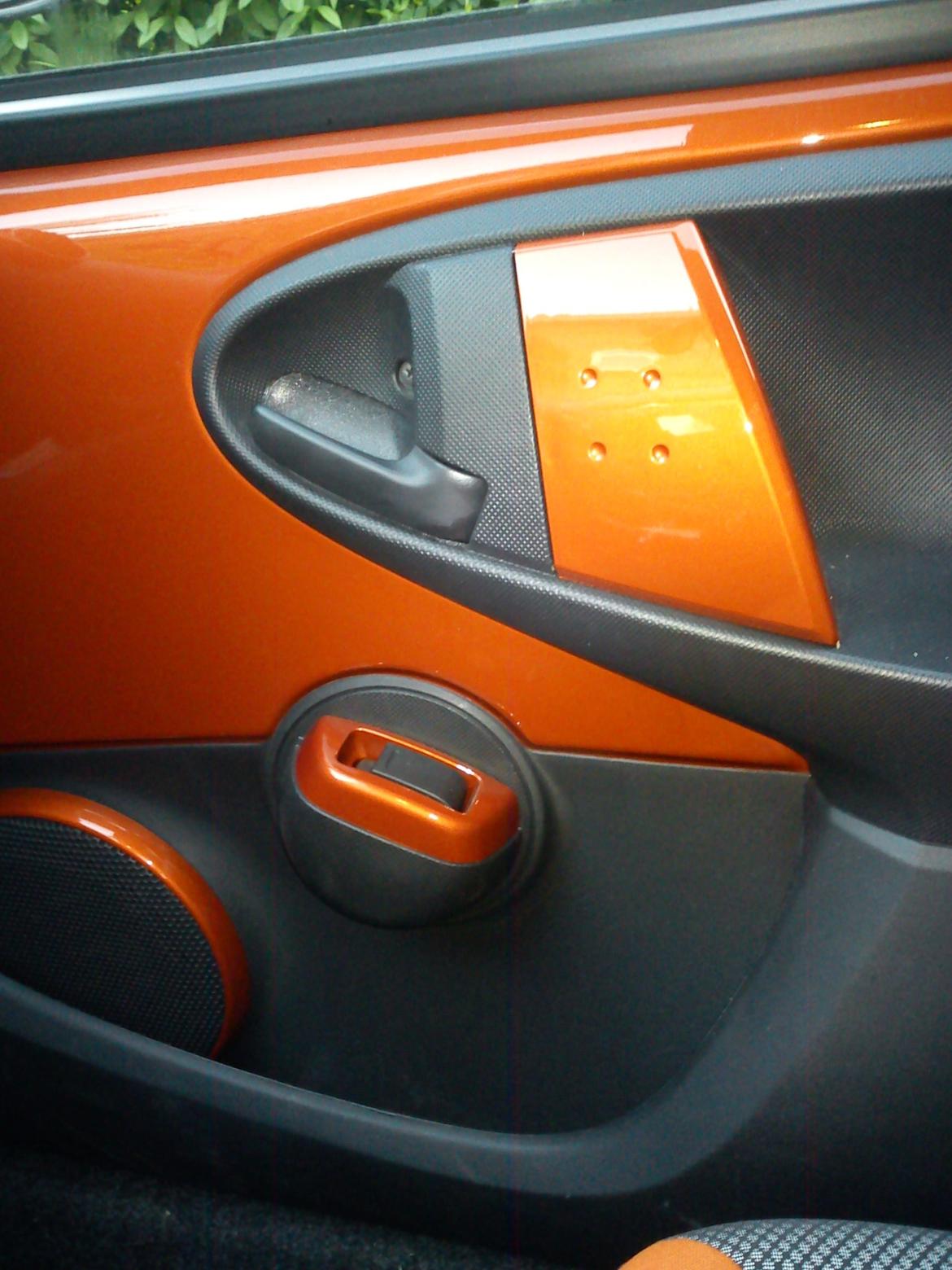 Toyota Aygo T2 Air Spice Edition - Indfarvet dørgreb og ringen rundt om elrude kontakterne billede 12