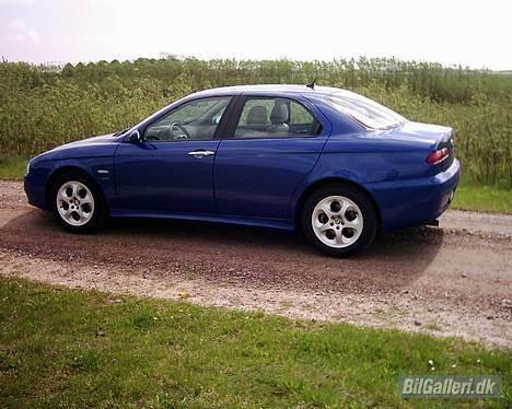 Alfa Romeo 156 1,9 JTD 16v RST - En lækker alfa med en pile lund i bagrunden billede 4