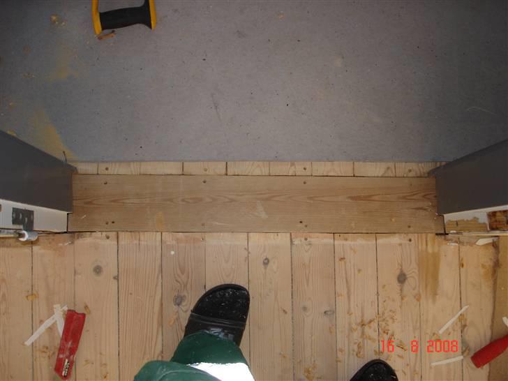 Fjernelse af dørtrin - Her ses planken fra oven. Jeg er dog ikke helt tilfreds med resultatet, da jeg ikke havde hverken dyksav eller Feinskærer til rådighed da jeg skulle skære kanterne rene, før nedlægning af planke. Kanterne er skåret med en stiksav. billede 6