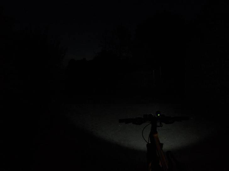 Cykel lygte i mørke billeder - Her ses lygten i sin svage position.
Den har 3 indstillinger
1. Kraftig 900 Lumens
2. Svag/Normal styrke som her på billedet ca. 200 Lumens.
3. Flashing Kraftig (ikke noget brugbart andet end at få folk med epilepsi til at gå amok :P )
 billede 7