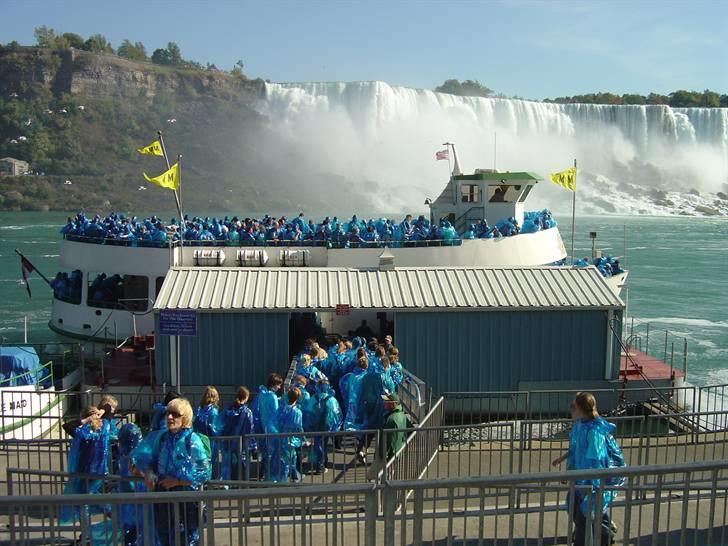 Min tur til Canada - Så er vi sørme ude og se Niagara Falls. Niagara Falls er faktisk flere vandfald, og det stykke land I kan se på den anden side af båden.. det er USA! .. Jepsen.. SÅ tæt har jeg været på USA ;o)
Båden der på billedet hedder "Maid og the Mist". Det navn har den fået pga. en historie om en indianer pige som eftersigende en gang for mange mange år siden skulle have forsøgt at sejle over vandet der i sin lille kano. Men strømmen i vandet var så stærk at den lille indianerpiges kano kæntrede og pigen omkom. Derfor hedder båden sådan. Og alle på båden lignede smølfer fordi de delte gratis BLÅ regnslag ud :o) billede 9