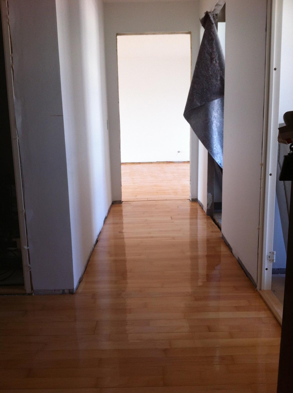 Lejlighed - renovering - Gangen er næsten malet færdig. Gulvene er blevet slebet i hele lejligheden, og har netop fået første omgang lak på dette billede. billede 24