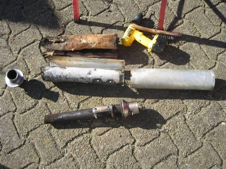 Ompakning af Termignoni-potte - Nitterne blev boret ud, og potten splittet ad. Ulden samt aluskjoldet i venstre side blev kaseret. Som der ses, måtte jeg spænde et rustfrit spændebånd fast på hver side af bespændingen. Disse blev sikret af popnitter. billede 2