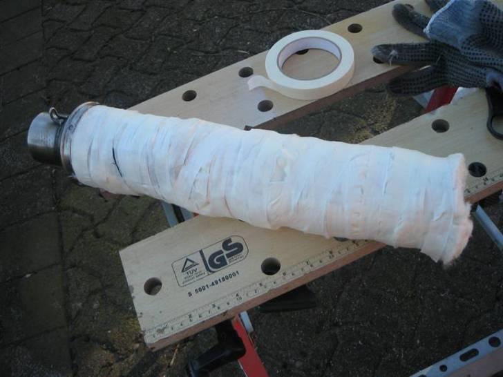 Ompakning af Termignoni-potte - Inderdelen blev renset og potteuld viklet stramt om (temmeligt bøvlet). Til fiksering brugte jeg alm. malertape. Derefter proppede jeg yderrøret på igen (med en blå tommel til følge). billede 4