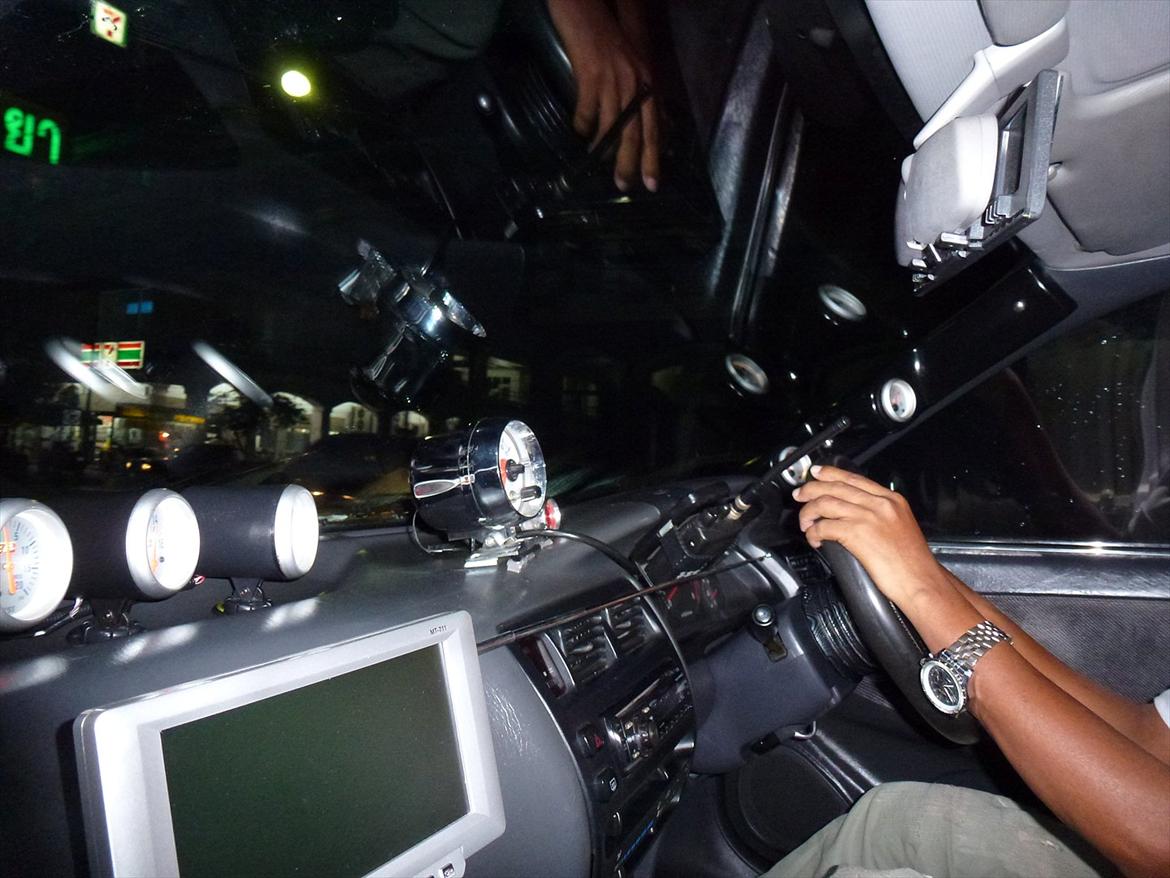 Thailand rundt på MC  - Nå velankommet til Puhket skulle vi lige have en taxa ned til hotellet for at skulle flyve vider 1500 km nord på næste dag
Denne taxa kunne man godt kalde en Batmobil, den havde alt i instumenter og i flere udgaver, men køre bil kunne han ikke, sikkert fordi han var blind, den unge fyr sad oppe i forruden og vi var ikke oppe på 60 km/t en eneste gang over en 25 km strækning billede 244