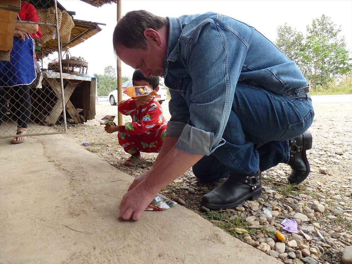Thailand rundt på MC  - Pause, og skulle lige hjælpe en knægt med at lave papirs flyver, nøøøj den knægt og hans mor blev glade  billede 281