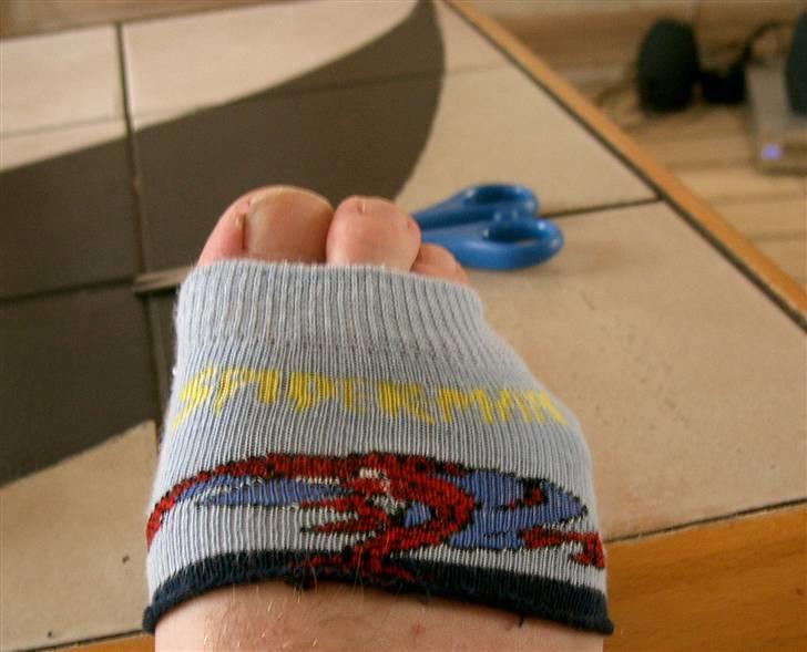 Sådan fixer man en brækket tå.. - Træk toppen af spiderman strømpen ned over foden, både fordi det støtter og ser smart ud. billede 7