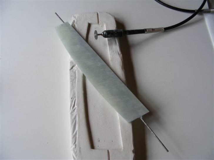 Forlængelse af køl på Sea Queen - Efter endt hærdning lirk den nye køl op ved at tage fat i gevind stykket, stille og roligt.
Fjerne det overskydende galsfiber / polyester - det er løbet oven ud, med en mini drill påmonteret en skære skive.
Husk støv maske, og det hvide pulver klør a. h. til, så udfør ikke slibearbejdet i korte bukser, men gerne uden for. billede 16