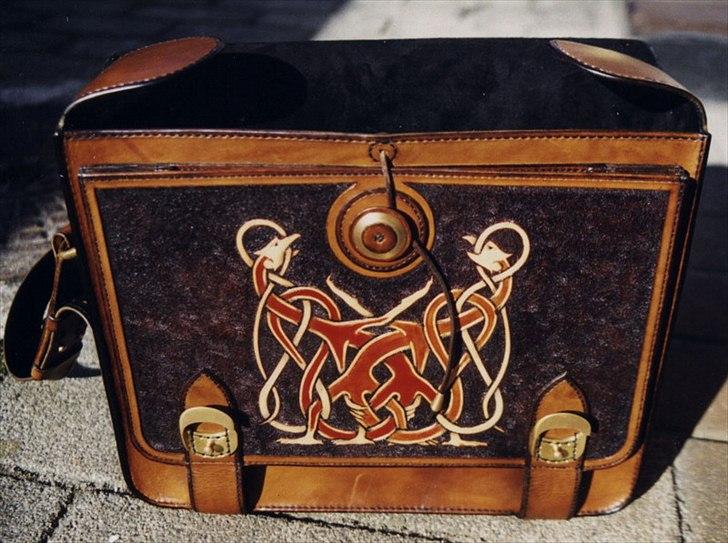 Min anden hobby 3, Læder Billeder - Et af de forsøg jeg lige skulle afprøve er denne lomme til løse papir, ligesom i en dokument mappe.
Lukningen er også lidt af et forsøg, det er en kendt lukning på papir mapper men er ikke brugt på læder tasker.
Knappen er lavet af en skive messing imellem to stykker læder og er ellers syet på ligesom en almindelig knap.
Læderet under knappen er også forstærket så lædersnøren ikke presser læderet ud af form.
Det har virket fint i godt 12 år nu, så jeg må vel ha´ lavet noget rigtigt ;-)
 billede 25