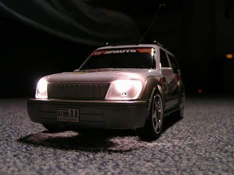 Bil Toyota Land Cruser - Set skråt forfra i lys, med lys på billede 12