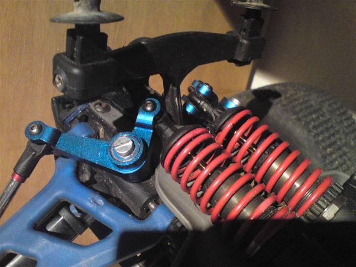 Bil Traxxas E-revo BRUSHLESS!  - Her kan man se nogle af de nye stumper der er blevet sat på. Der er sat rocker arms, dæmperholdere, servo beskyttere og en ting der beskytter styrtøjet på alt sammen i blå alu. billede 13