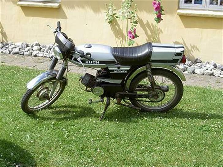 Puch Grand Prix & Monza modeller i DK. - Monza N-SL2
Ja, desværre blev der jo i 1980 indført nye regler, som betød at man ikke længere kunne sælge de store maskiner. Man måtte nu maks have 2 gear i motoren, og knallerten måtte maks veje 65kg, og man måtte kun have kort saddel. Derfor måtte man barbere en hel del af vægten på de tunge Puch knallerter.

Farve: Sølv eller Brun

Kendetegn: "klik-klak" motor, "madkasse" bag sædet, plastik kædeskærm, plastik svinghjulsdæksel, lille forlygte (120mm), ingen omdrejningstæller, maxi bagbremser, maxi cylinder og topstykke, firkantet maxi karburator. billede 9