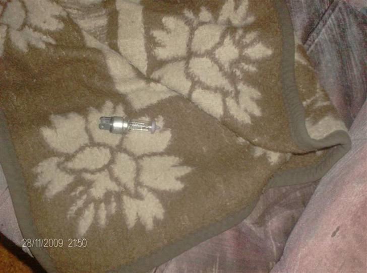 Guide til montering af H4 pære i orginal fatning - Så fik jeg kransen af. dette skal man passe på med da kransen holder fatningen og selve glasset sammen. ( den er delt i 2 ) inde underkransen. selve fatningen på denne pære er 22mm og hullet i fatningen er 20mm så vi snakker om få mm. som man kan se er der 1 anden krans på den også lad den blive da den støtter pæren billede 2