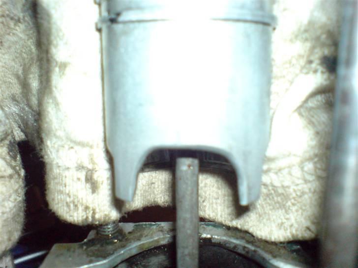 Renovering af puch motor. - 2 gear automatic handikap. - Ja, et hakket stempel er jo i og for sig godtnok, men... Man hakker bare ikke et stempel så meget som det er gjort her. Ud over det er det osse gjort pænt skævt, og igen smider man stemplet ud af balance, og risikerer derved at smadre en masse andet.

Det er jo som i nok kan høre en gang lort der er lavet her, men det blir bedre endnu. Hakket sidder i UDSTØDNINGSSIDEN!!!! JA,du læste rigtigt,fuck hvor er det dog en dummefejl af den værste slags. Skal man ændre på udstødningskanalens porttid gør man det i TOPPEN af stemplet, det er meget meget lidt man skal ændre i bunden, før man har fucket bagkompressionen så meget op, at motoren slet ikke kan trække, og i værste tilfælde slet ikke køre overhovedet.

Konklusion: Nyt stempel, 150kr for et org.

Ja som i nok kan høre har jeg vist allerede fundet flere grunde til at motoren ikke er så glad for livet, men for at være på den sikre side går jeg grundigt til værks og ser hele motoren efter, for hvis resten er bare halvt så meget noget lort som det her, så blir jeg sq bange!! Manden der har lavet det her har jo trods alt bil og det hele, hehe.

FORTSÆTTELSE FØLGER! billede 8