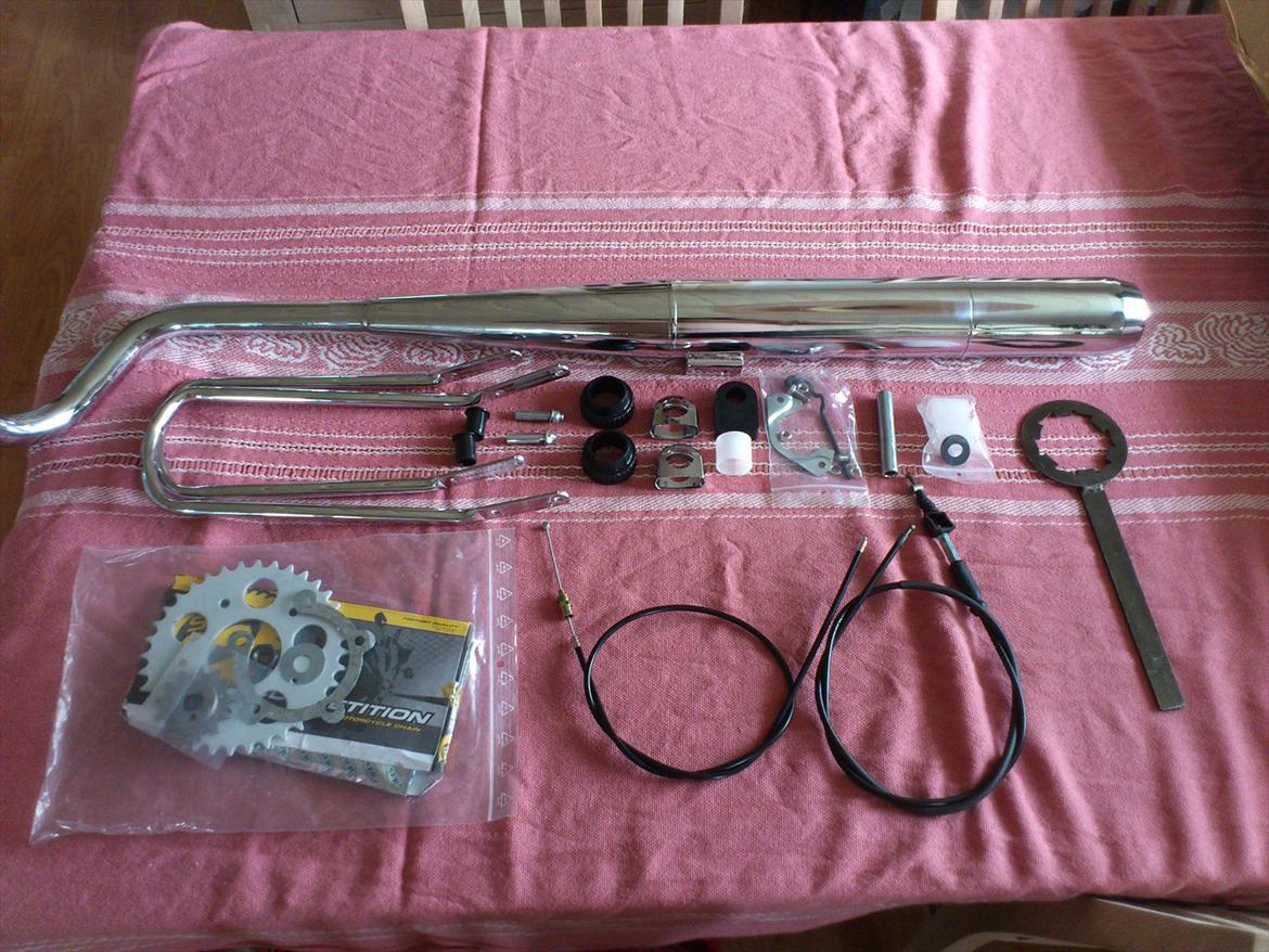 Kreidler Florett RS 1974. - Så kom den første omgang stumper. Eftersom dette er et "low budget" projekt, så har jeg kun bestilt stumper som jeg ikke havde mulighed for at genbruge. Der er kommet følgene i denne sending: Udstødning og forrør, skærmstivere til forskærmen, renoveringssæt til forgaflen, nye "sportssimmeringe" til forgaflen, nyt forgaffelstop og kabelbuide, nyt kædekit med tandhjul (13/36, vil dog have et lovligt 11 tands foran i stedet), låseblik til tandhjul, og møtrik til fortandhjulet. Nyt forbremsekabel, og gaskabel. Nye bøsninger, og kilebolte til bagsvingeren, ny beskyttelsesbøsning til stellet (så kæden ikke slæber på), ny bøsning til centerstøttebenet, nyt anslagsgummi til centerstøttebenet (så centerstøttebenet ikke banker op i udstødningen), nye chrome hætter til styrbeslaget, og et stykke koblingsværktøj, til næste gang jeg skal renovere en motor. Næste sending kommer til at indeholde dele til at renovere begge hjul.

 billede 33