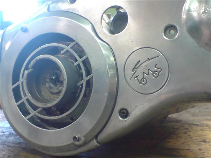 Renovering af puch motor. - 2 gear automatic handikap. - Det fiiine Tomos logo. :) Så er det vidst bekræftet at de ældre tomos motore er meget lig de ældre puch motore? :) Eller hvad? ;)

Det er så småt ved at være klar til montering. Det sidste der skal gøres ved den dejlige motor er følgende:
Der skal konstrueres et skjold til at dække over åbningerne i svinghjulet, så der ikke kommer skidt og snavs i tændingen.
Der skal konstrueres en pakning til koblingshuset, da den indkøbte pakning ikke passede efter noget som helst. :s
Der skal konstrueres en prop til at dække det store hul til kickstart i koblingsskjoldet. billede 33