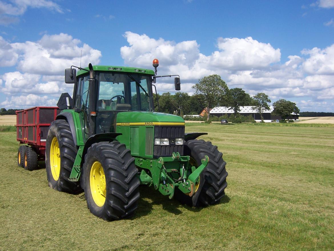 John Deere 6900 - En varm dag i frøhøsten med gården i baggrunden billede 16